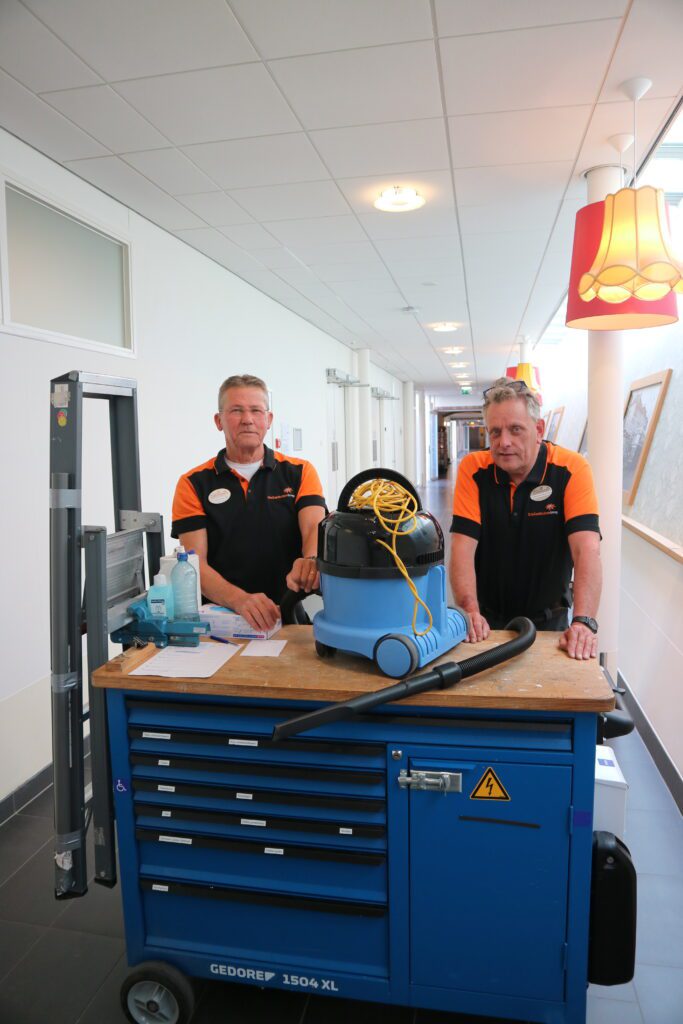 Ruud en Willem van de Technische Dienst in de gang van Insula Dei.